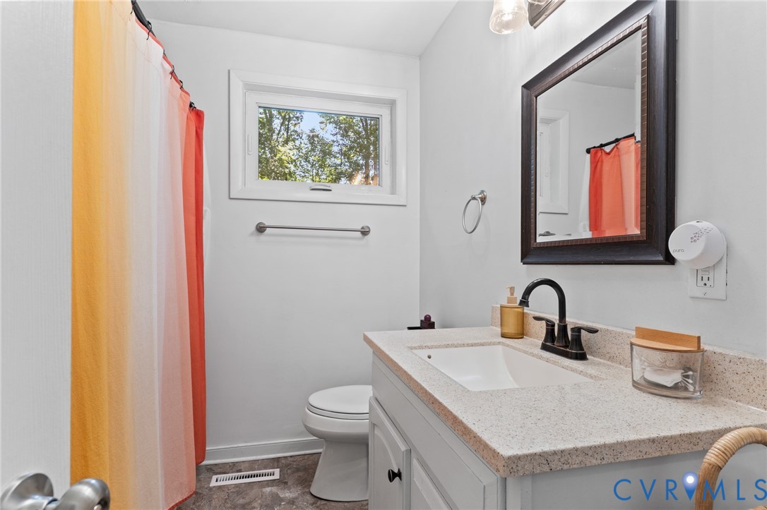 Bathroom features an updated vanity and vinyl tile floors