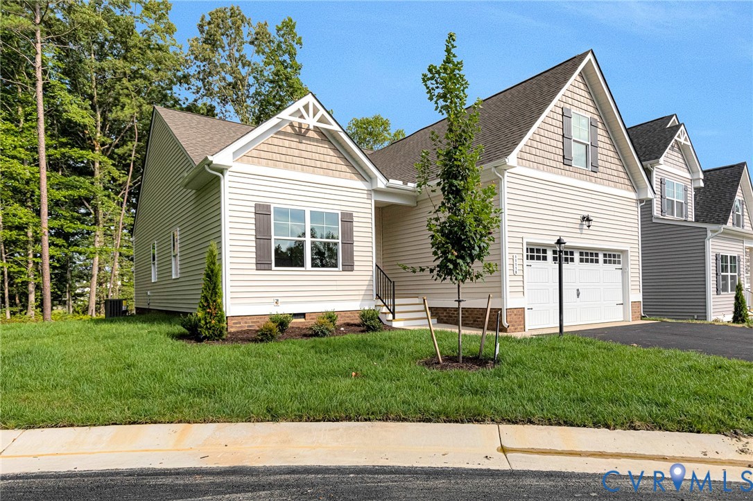 Contemporary residence featuring light-colored siding, a two-car garage with carriage-style doors, and a gable roofline