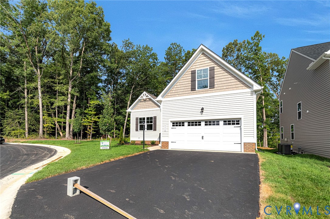 Two-car attached garage with white panel doors and upper window accents