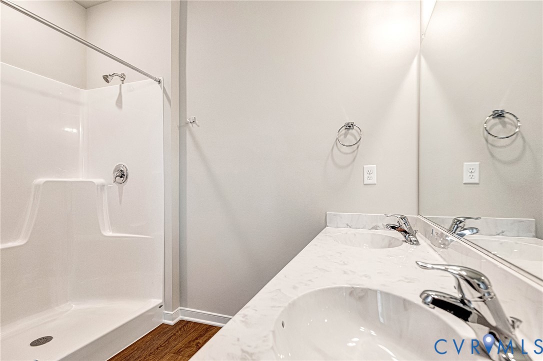 Bathroom featuring a dual-sink vanity with a light-toned countertop, integrated sinks, and chrome faucets