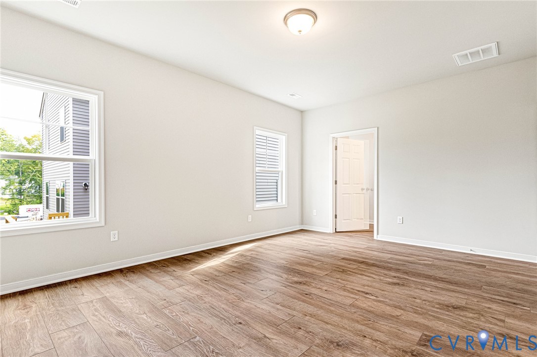 Spacious room featuring wood-finish flooring and neutral wall tones