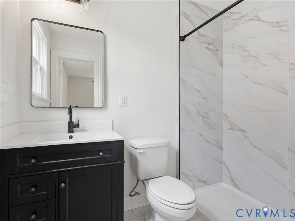 Modern bathroom featuring a black vanity with a white countertop and integrated sink