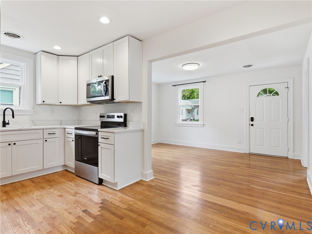 Kitchen featuring white shaker cabinetry, stainless steel appliances, and white countertops with a matching backsplash Kitchen featuring white shaker cabinetry, stainless steel appliances, and white countertops with a matching backsplash