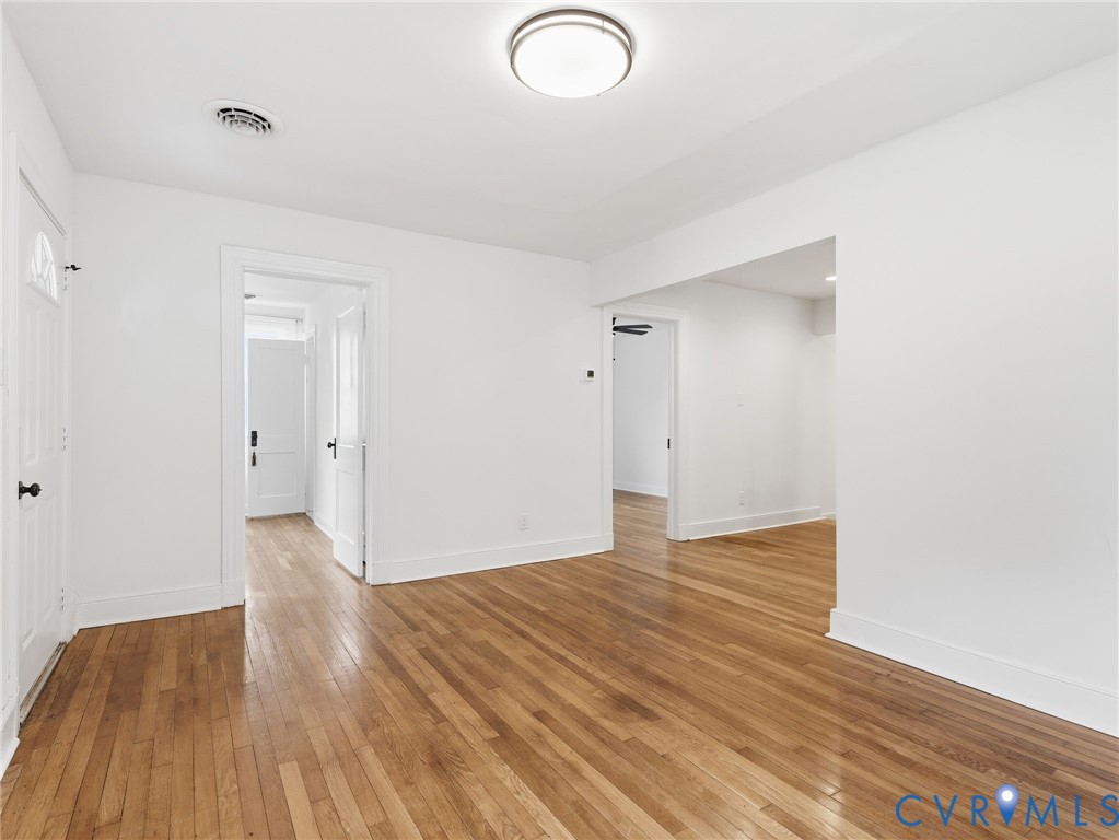 Hardwood flooring throughout, white baseboards, and bright white walls Hardwood flooring throughout, white baseboards, and bright white walls