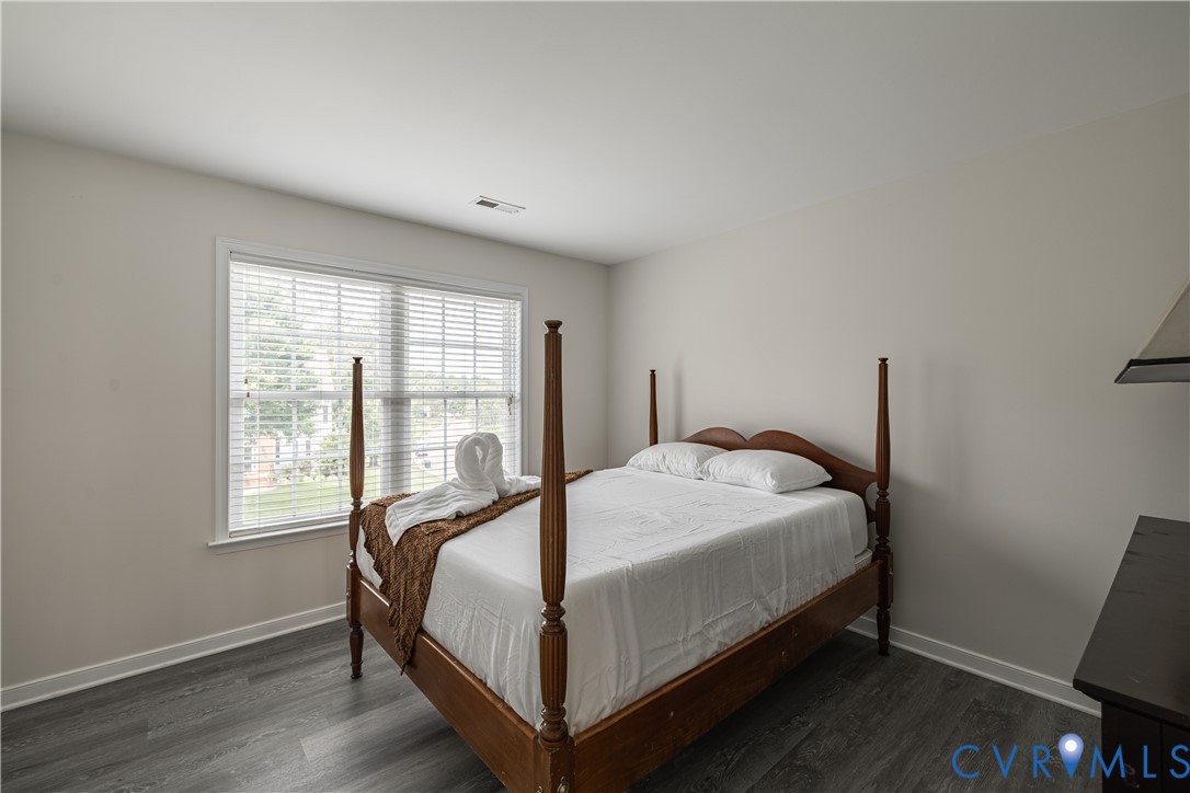 Spacious room featuring wood-finish flooring and neutral wall tones