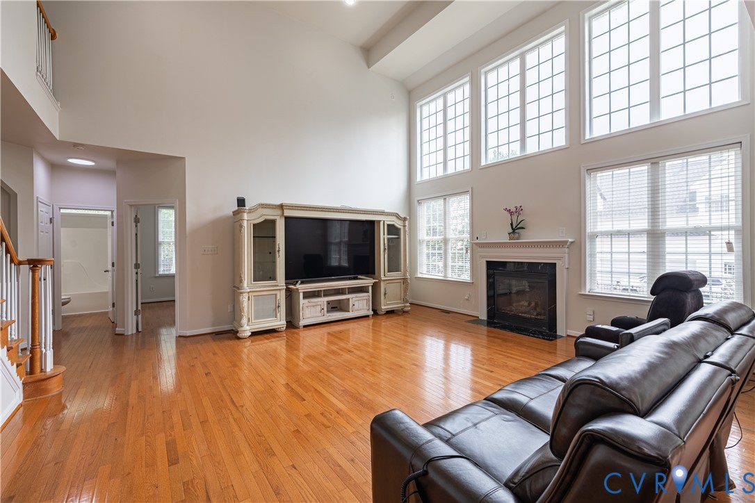 Two-story living area featuring hardwood flooring Two-story living area featuring hardwood flooring