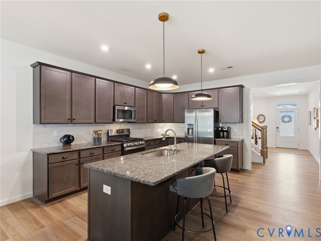 Designed for gathering, cooking, and living this kitchen blends luxury finishes with everyday functionality. Wood laminate flooring. Designed for gathering, cooking, and living this kitchen blends luxury finishes with everyday functionality. Wood laminate flooring.