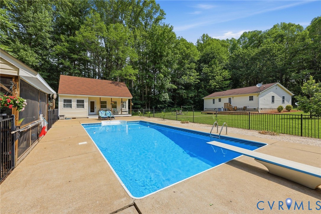 Fenced in-ground pool with screened porch, outdoor shower, poolhouse with covered porch, full bath, space for an office or any number of uses!