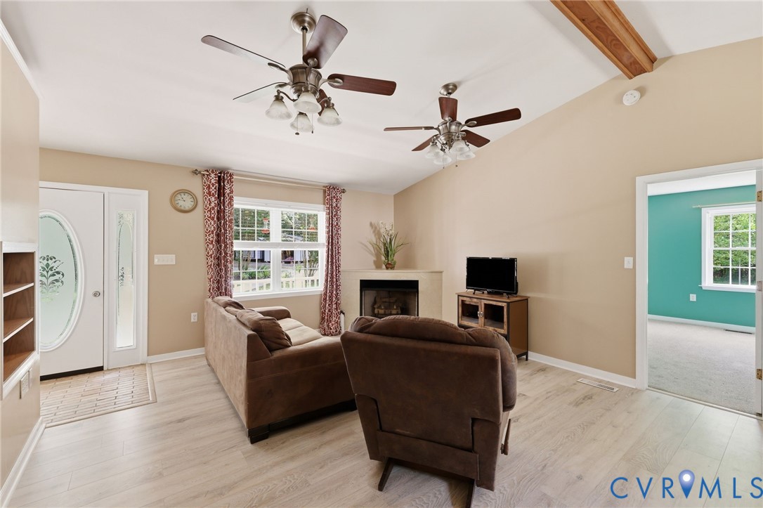 Living room/family room with new flooring, gas corner fireplace, cathedral ceiling.