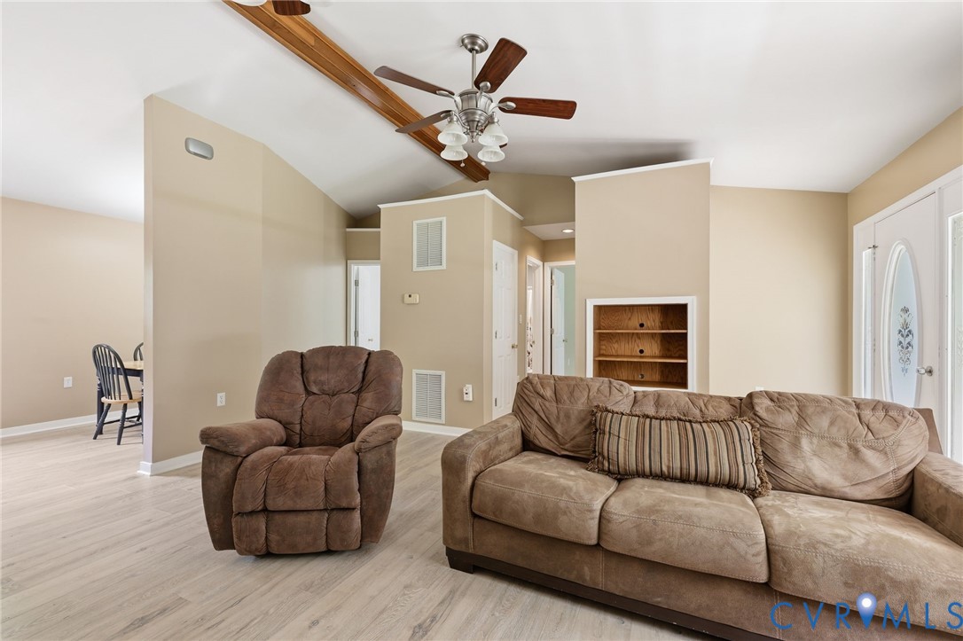 Living room/family room with new flooring, gas corner fireplace, cathedral ceiling.