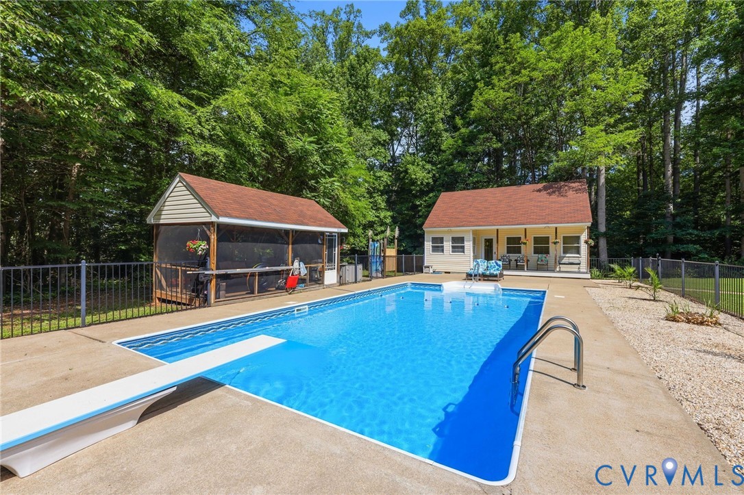 Fenced in-ground pool with screened porch, outdoor shower, poolhouse with covered porch, full bath, space for an office or any number of uses!