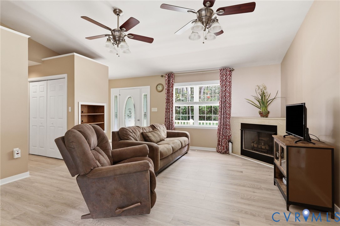Living room/family room with new flooring, gas corner fireplace, cathedral ceiling.