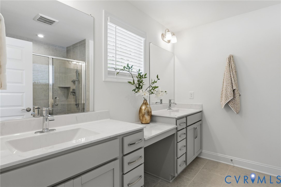 Bathroom featuring a double vanity with light gray cabinetry and white countertops
