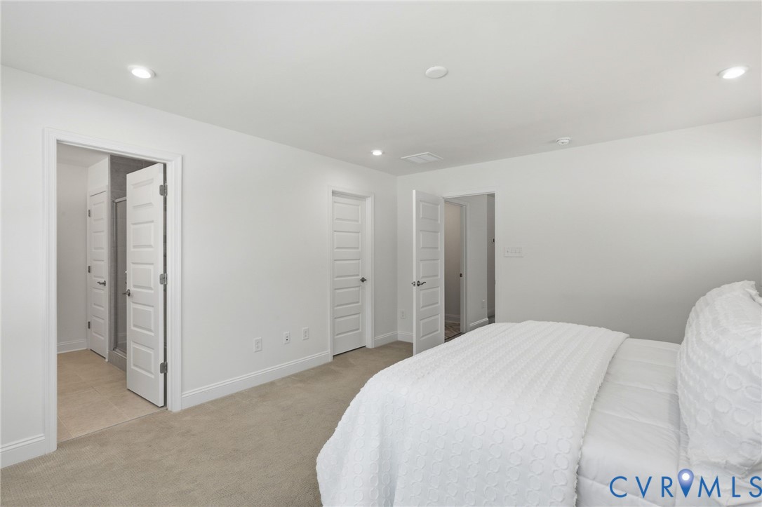 Neutral-toned wall-to-wall carpeting complements the white walls and trim