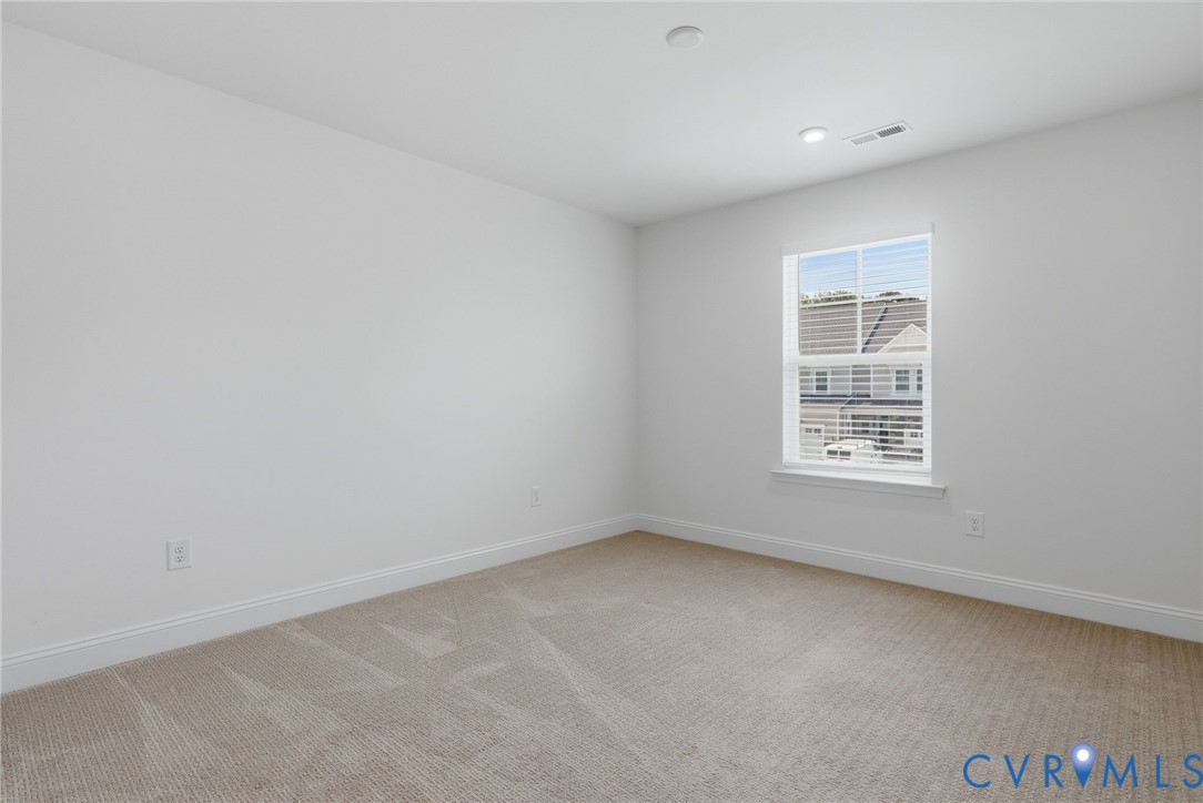 Neutral paint palette with recessed lighting and carpeted flooring