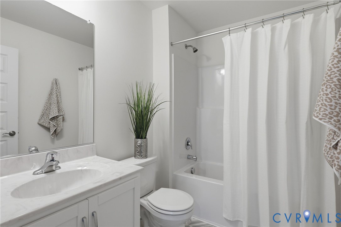 Bathroom featuring a white vanity with an integrated sink, polished chrome faucet, and a light-toned countertop