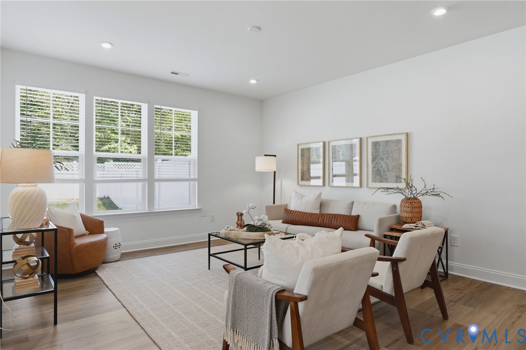 Spacious interior featuring wood-finish flooring, recessed lighting, and bright white walls