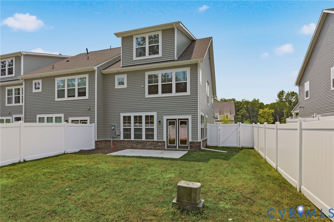 Expansive grassy yard featuring a private white vinyl fence