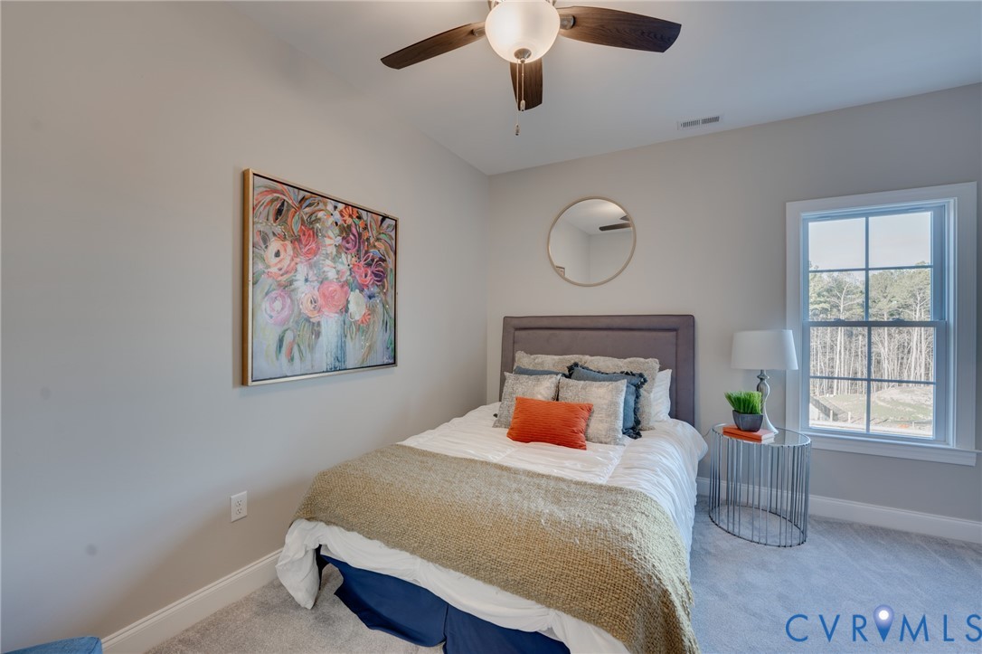 Bedroom featuring light gray wall paint, a ceiling fan with integrated lighting, and carpet flooring