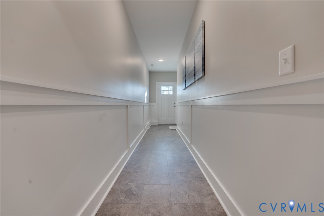Hallway featuring board and batten wainscoting, recessed lighting, and tile flooring