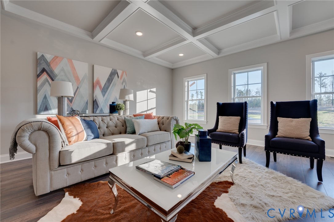 Spacious living area featuring a coffered ceiling, recessed lighting, wood-finish flooring, multiple windows, and light gray wall tones