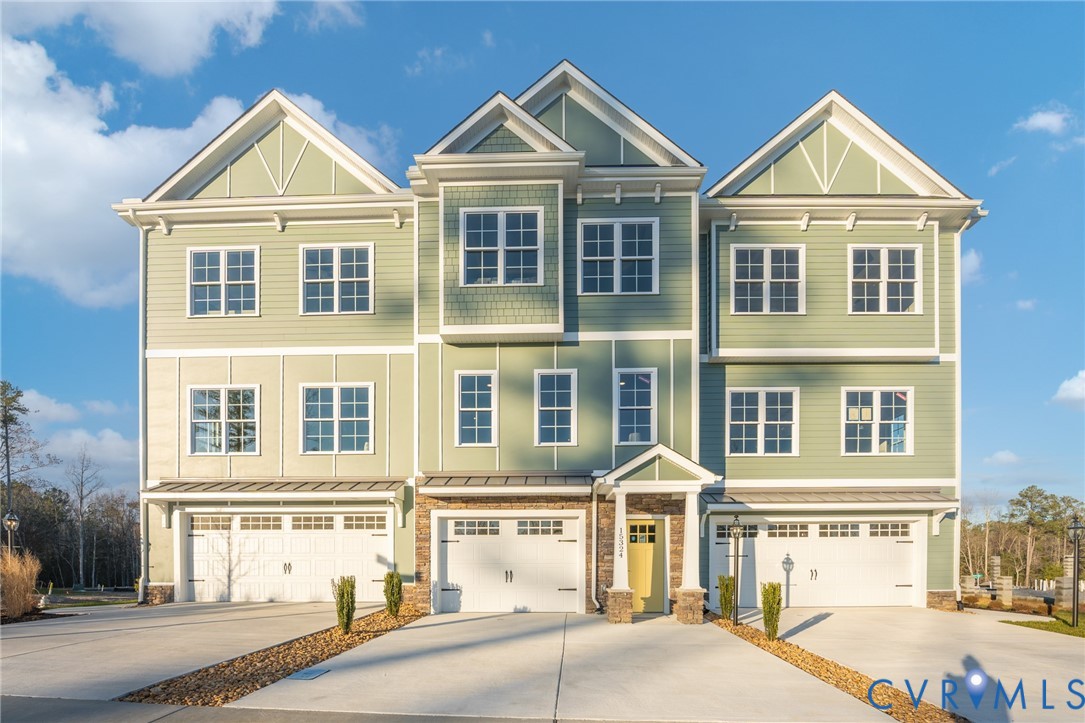 Contemporary townhome exterior featuring light green and beige siding with white trim Contemporary townhome exterior featuring light green and beige siding with white trim