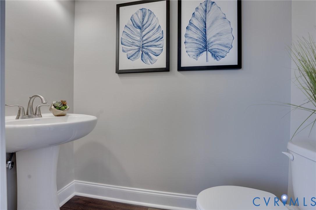 Pedestal sink with brushed nickel faucet, wood-finish flooring, and light gray wall paint