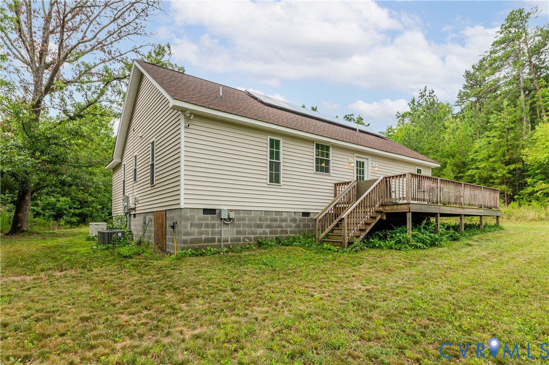 Exterior featuring horizontal vinyl siding, a brown shingle roof, and solar panels