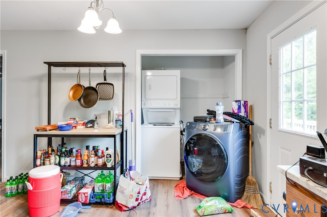 Laundry area with wood-finish flooring, light grey walls, and a multi-pane glass-insert door providing natural light