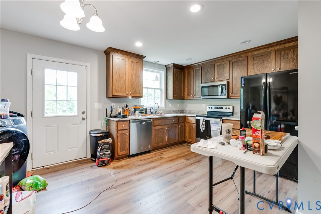 Kitchen featuring wood-finish flooring, recessed lighting, and a white paneled door with window inserts Kitchen featuring wood-finish flooring, recessed lighting, and a white paneled door with window inserts