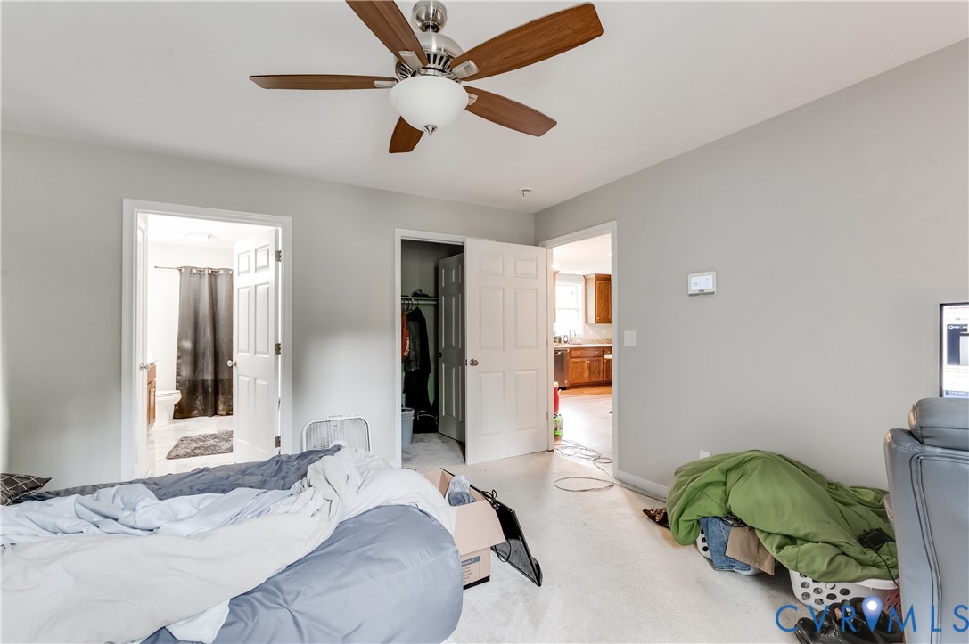 Carpeted room with a ceiling fan featuring wood-finish blades, light gray walls, and white trim