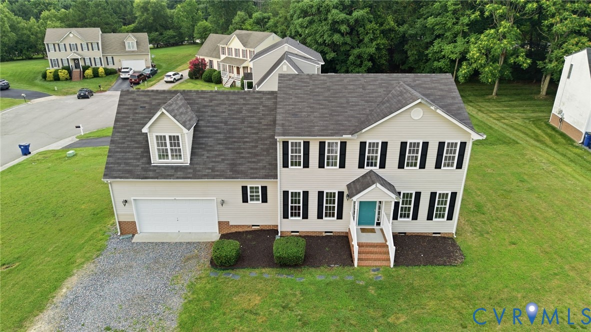 Two-story residence featuring light-colored siding and a dark shingle roof