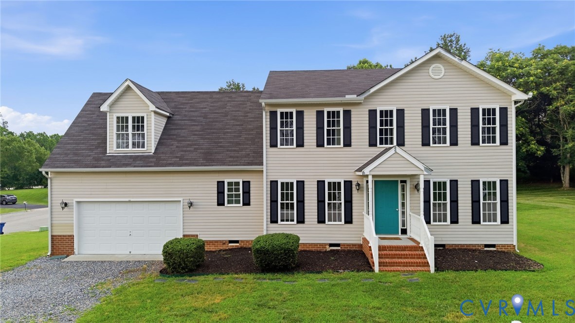 Traditional two-story residence featuring light-colored siding, black louvered shutters, and a prominent turquoise front door