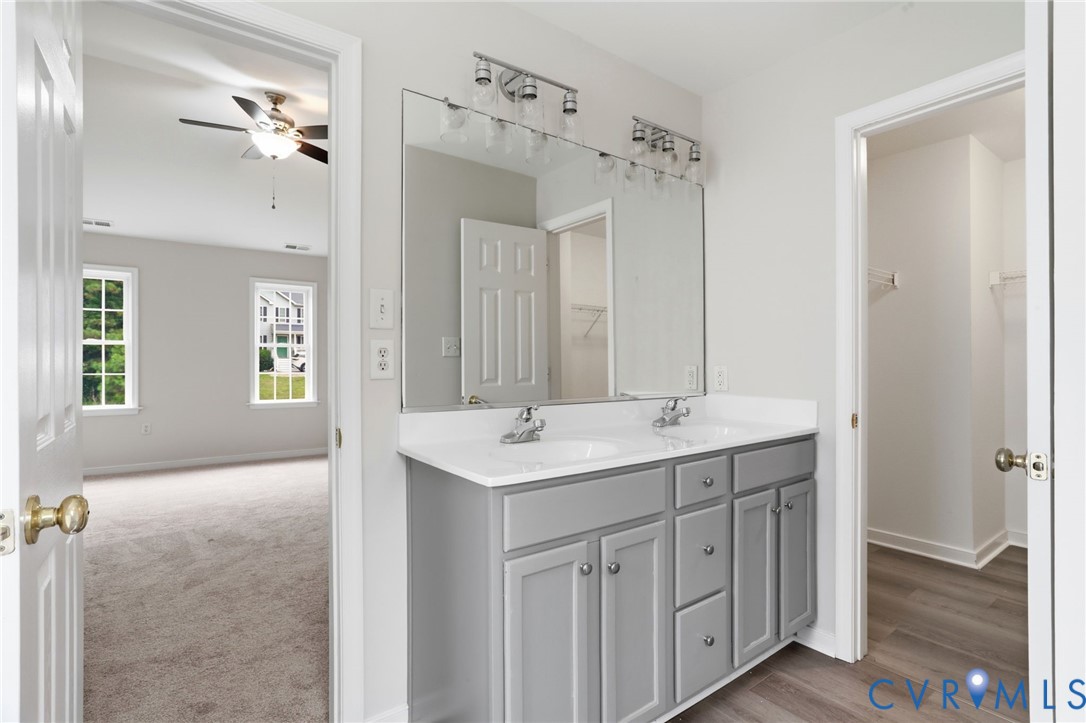 Double vanity with gray cabinetry, white countertops, and chrome fixtures