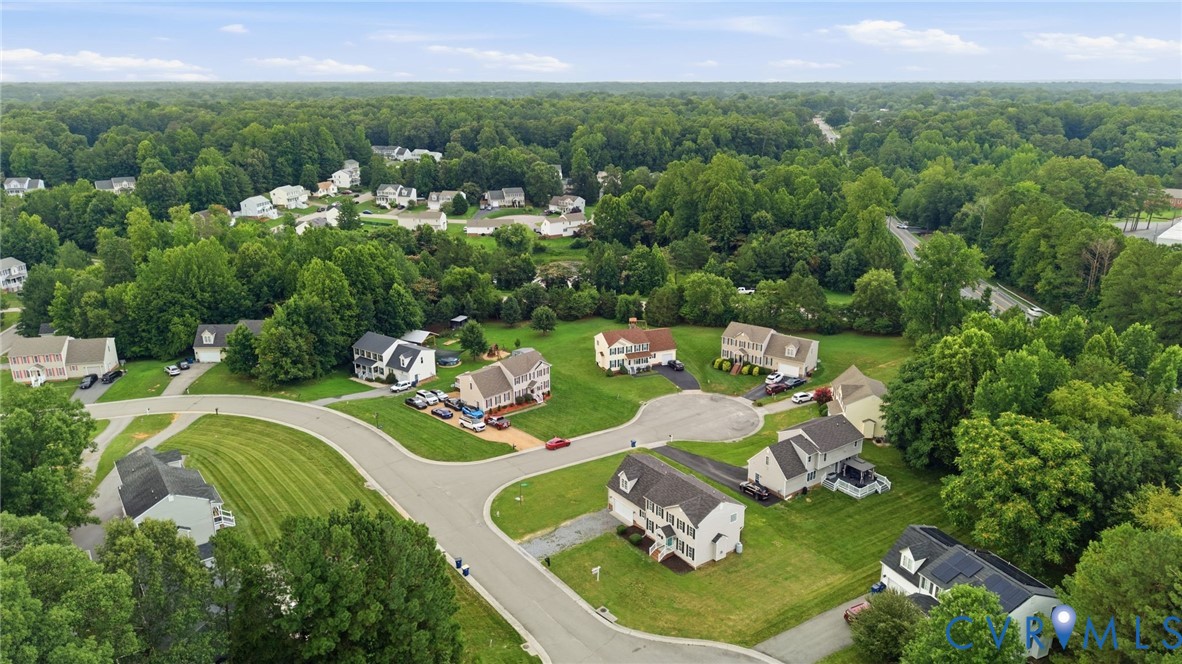 Aerial perspective showcasing a residential community surrounded by extensive mature tree cover