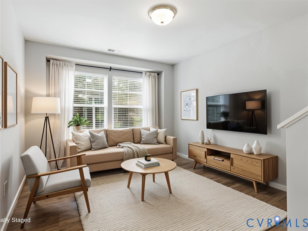 The second-floor loft offers a bright and versatile flex space, complete with luxury vinyl plank flooring and oversized windows that fill the room with natural light - perfect for a home office, media room, reading nook, or play area