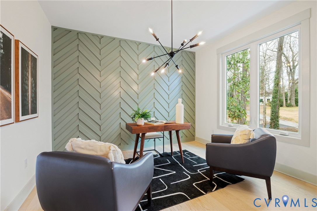Feature wall with a herringbone wood treatment, large windows with white trim, wood-finish flooring, and a modern sputnik chandelier