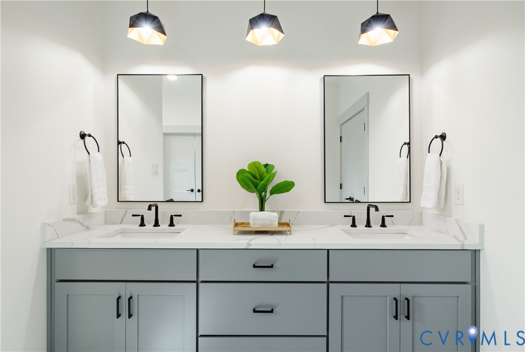 Dual vanity with shaker cabinetry, white countertop, rectangular undermount sinks, and matte black fixtures