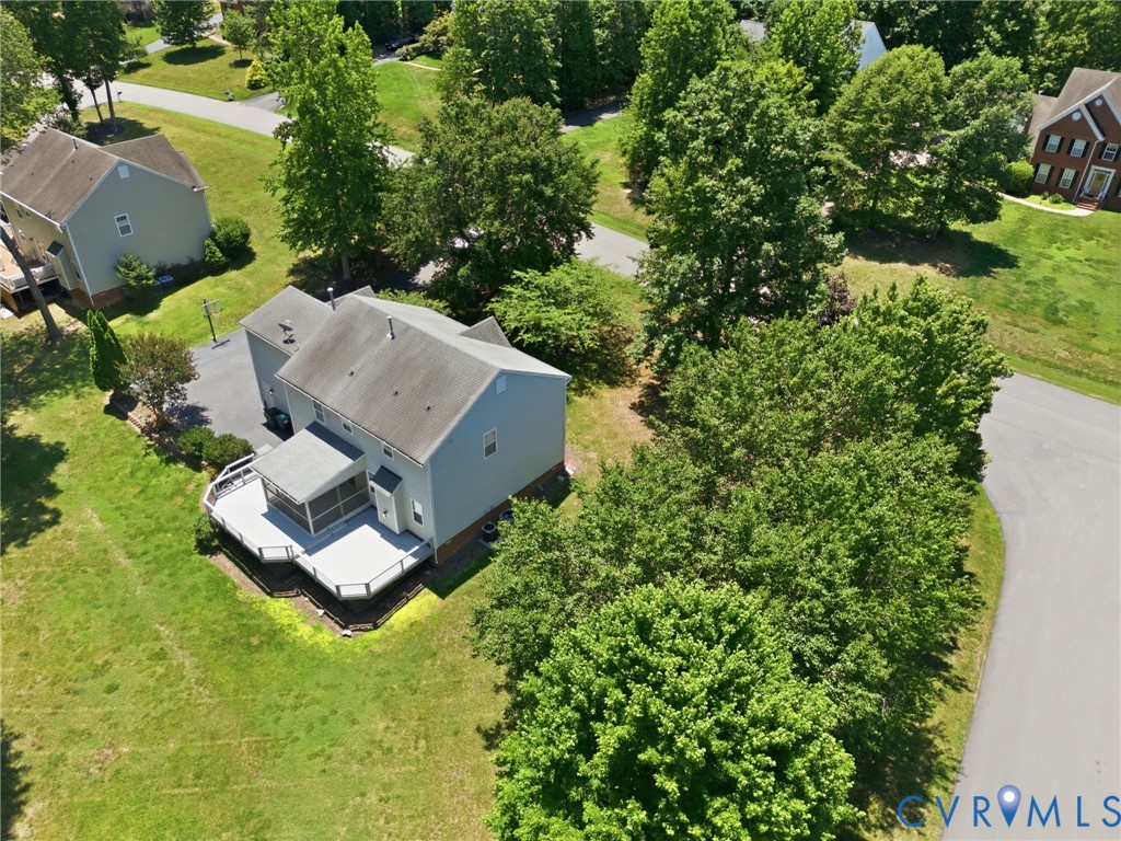 Rear exterior featuring a multi-level composite deck, screened porch, and mature perimeter trees