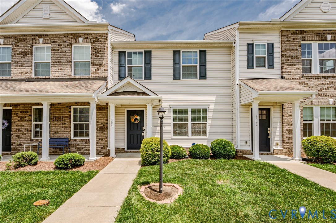 Townhome exterior featuring brick and siding accents
