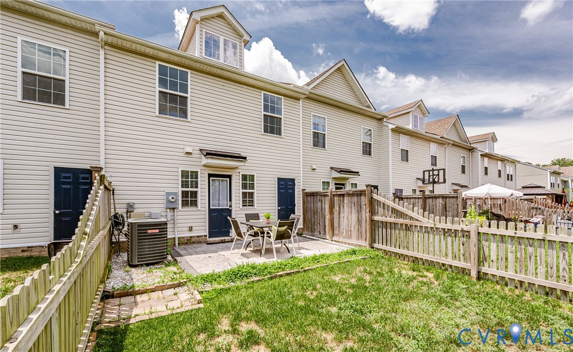 Private backyard featuring a paved patio and picket fence