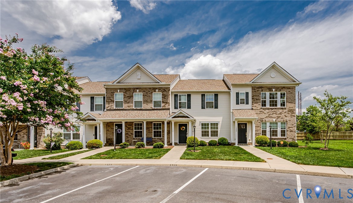 Townhome row featuring light-colored siding and brick accents