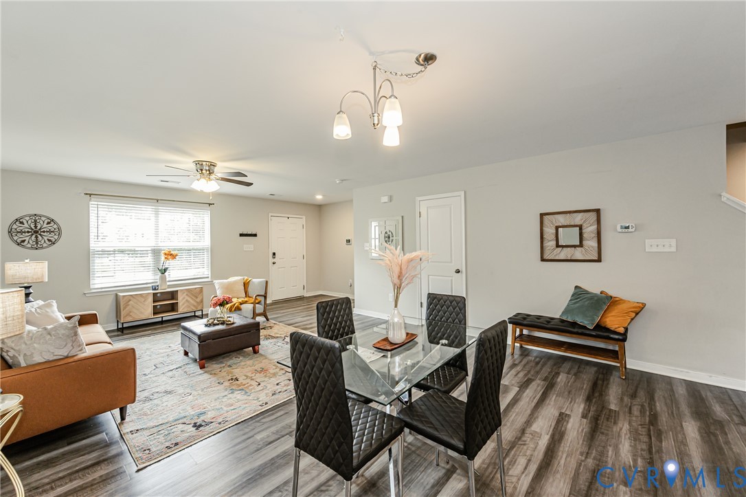 Open-concept living and dining area featuring wood-finish flooring, light gray wall paint, and white trim