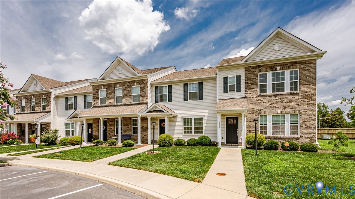 Townhome exteriors featuring brick and siding facades, gabled roofs, and manicured front lawns
