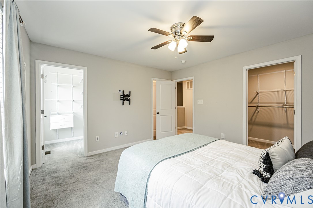 Carpeted bedroom with a ceiling fan, light gray walls, and white trim