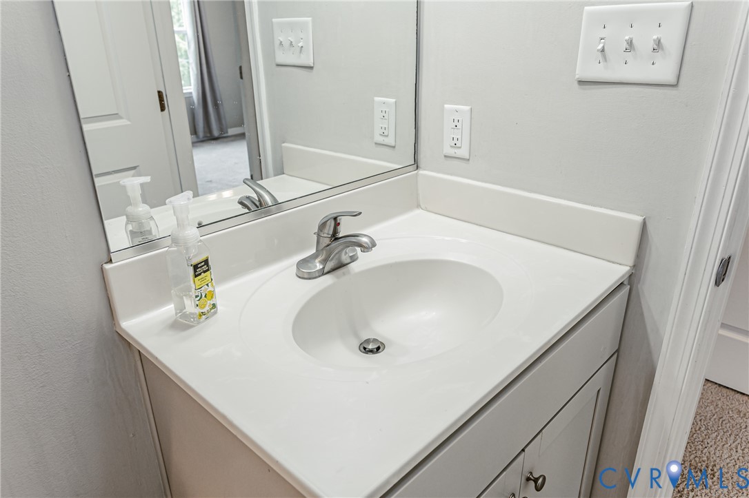 Bathroom vanity with an integrated white sink, brushed nickel faucet, and a large mirror