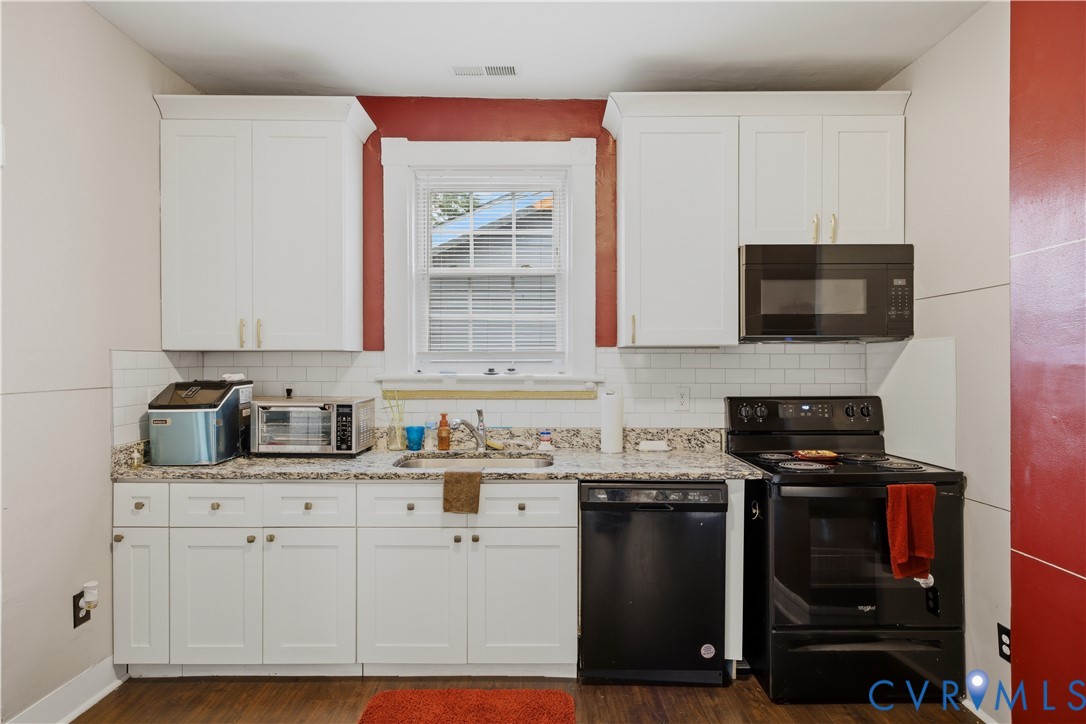 Kitchen featuring white shaker-style cabinetry, a built-in microwave, black dishwasher, and black electric range
