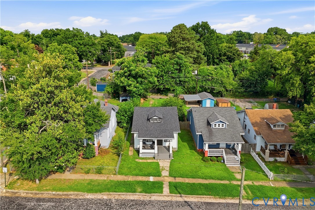 Gabled roofline residence with a front porch, dormer window, and mature landscaping