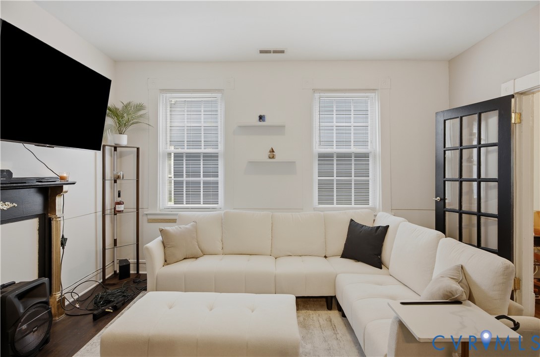 Living area with dark wood-finish flooring and light-toned walls