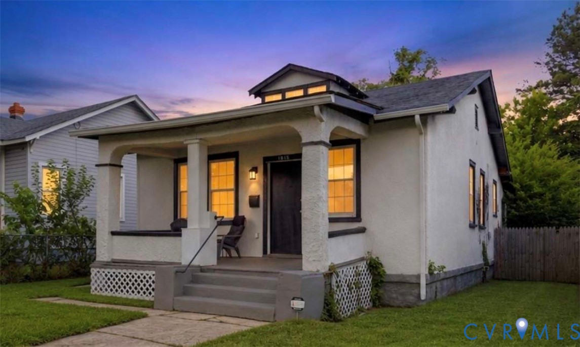 Charming bungalow exterior featuring a covered front porch, multi-pane windows, and a fenced yard Charming bungalow exterior featuring a covered front porch, multi-pane windows, and a fenced yard